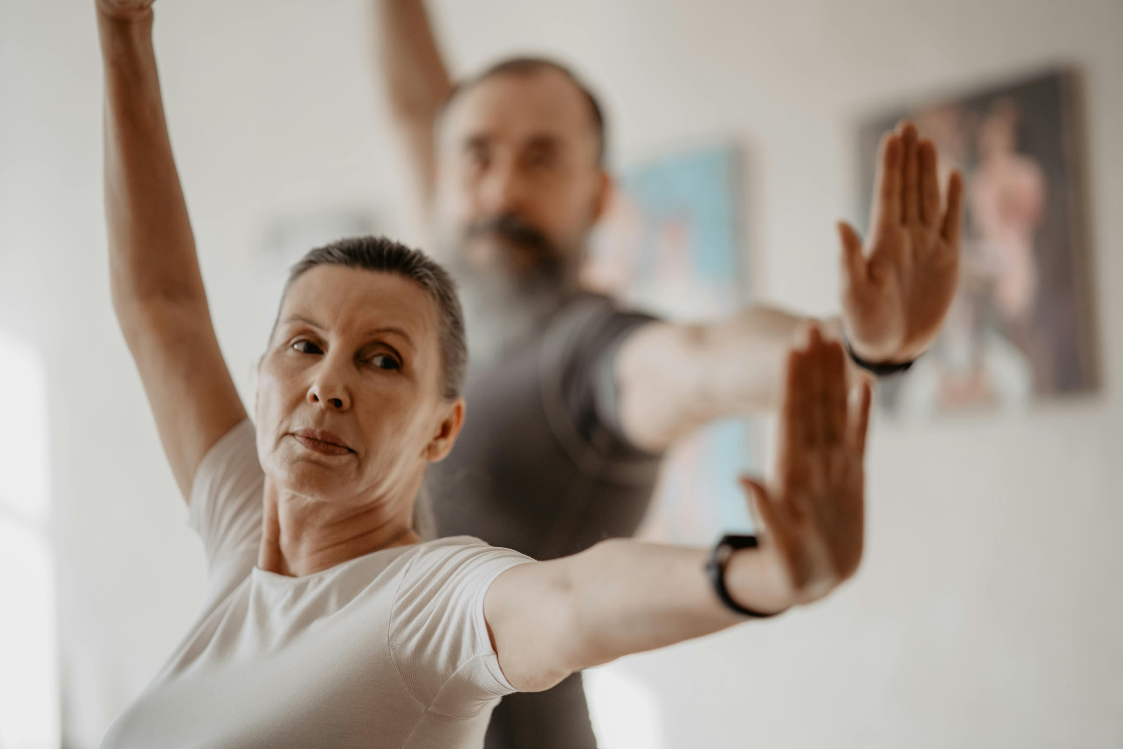 Older adults practising tai chi movement indoors