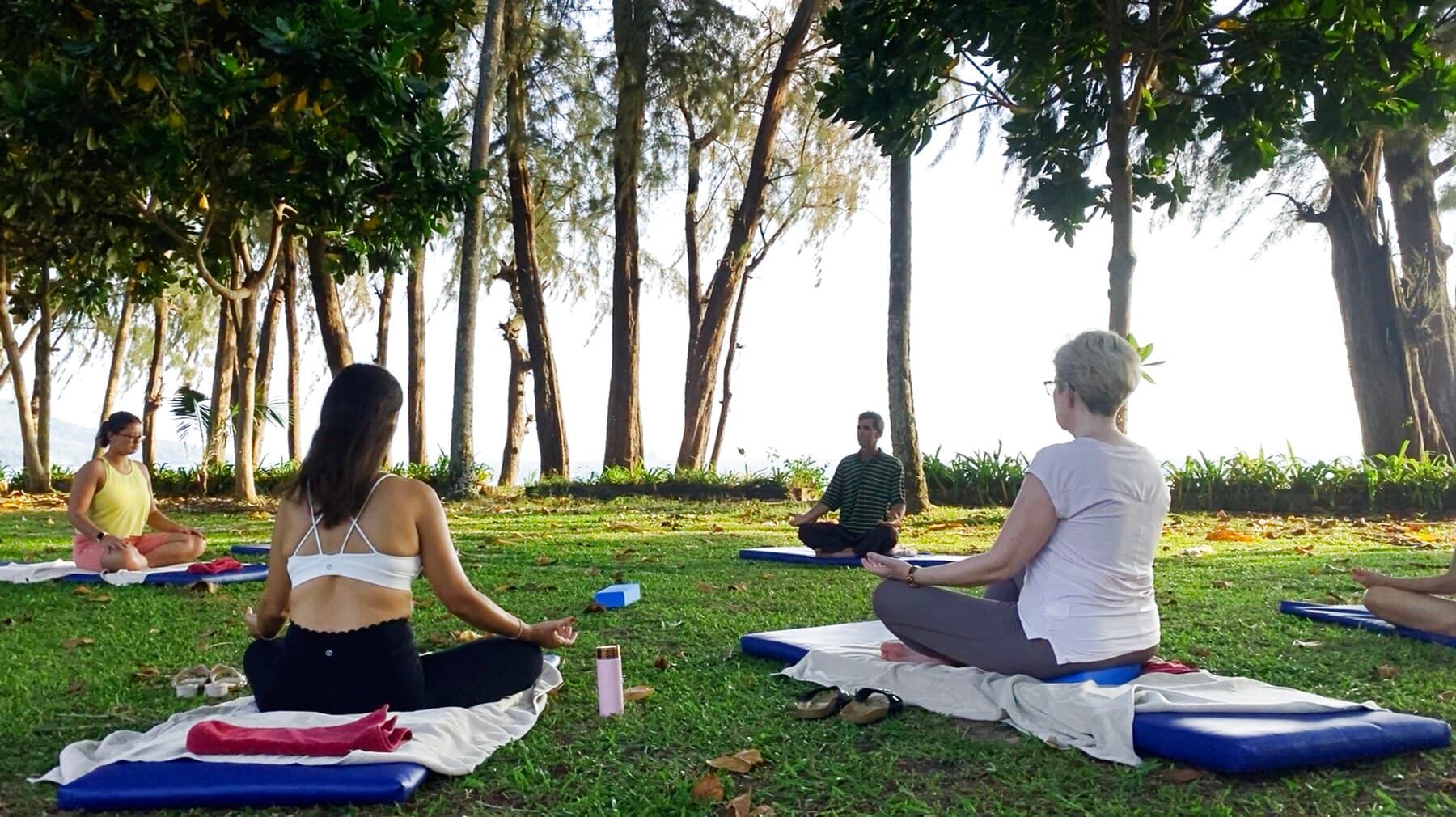 Evening meditation session under the trees by the sea